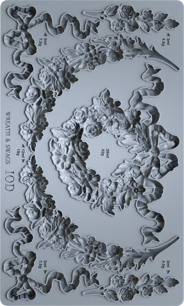 Decorative mold with wreath and swag designs on a gray background