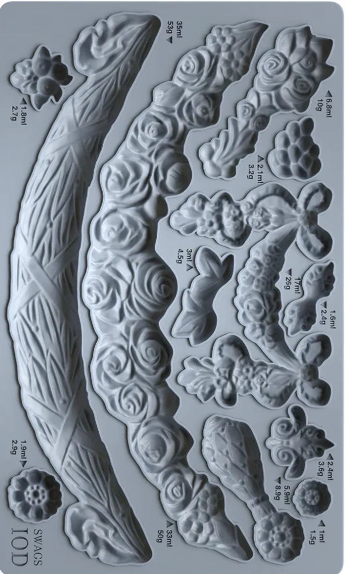Metallic mold with various floral and leaf designs on a gray background