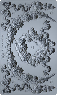 Decorative mold with wreath and swag designs on a gray background
