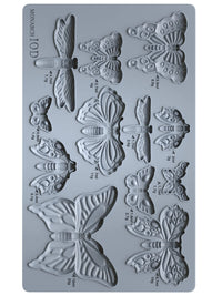 Butterfly-shaped silicone mold with measurements on a gray background