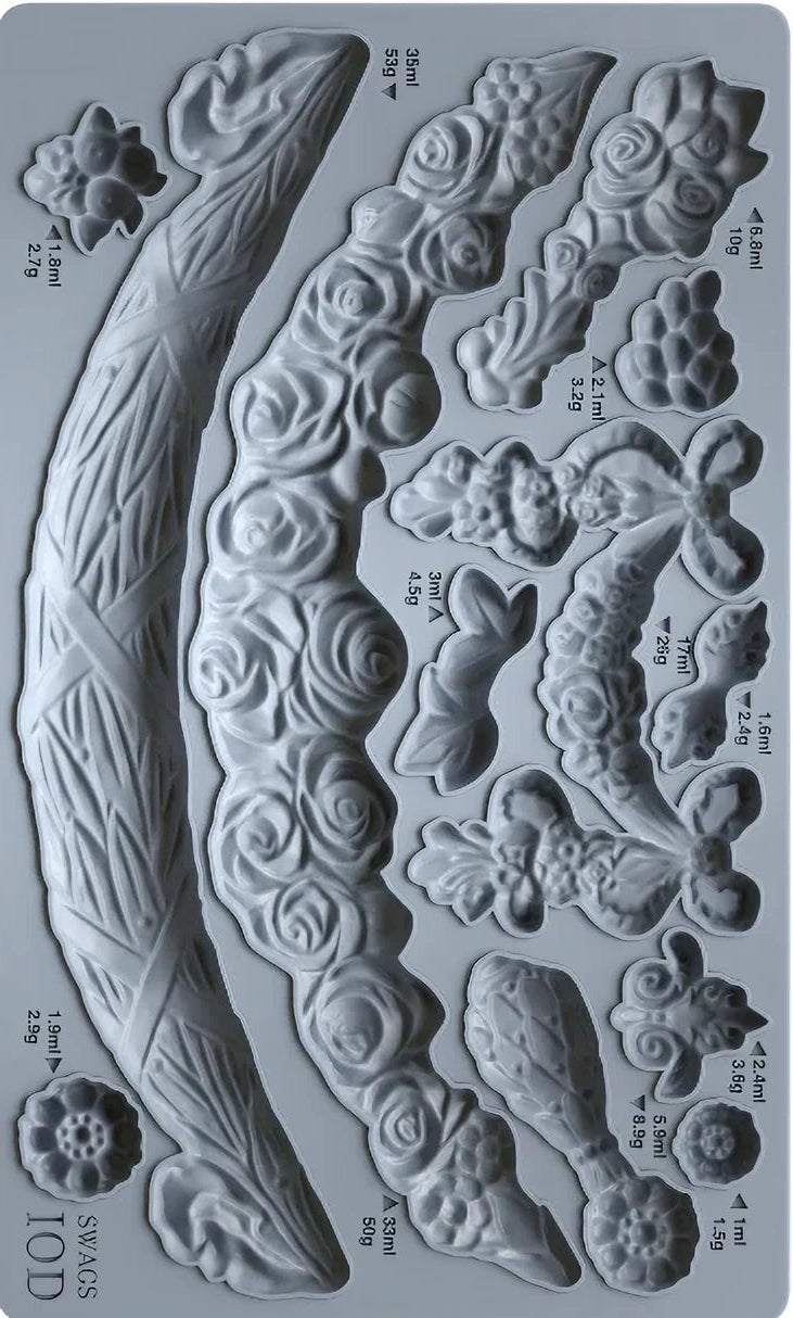 Metallic mold with various floral and leaf designs on a gray background